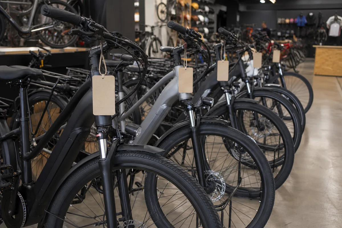 Rayon de vélos électriques alignés dans un magasin spécialisé avec étiquettes de prix